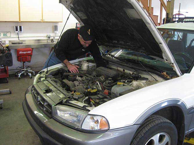 auto mechanic working on Subaru